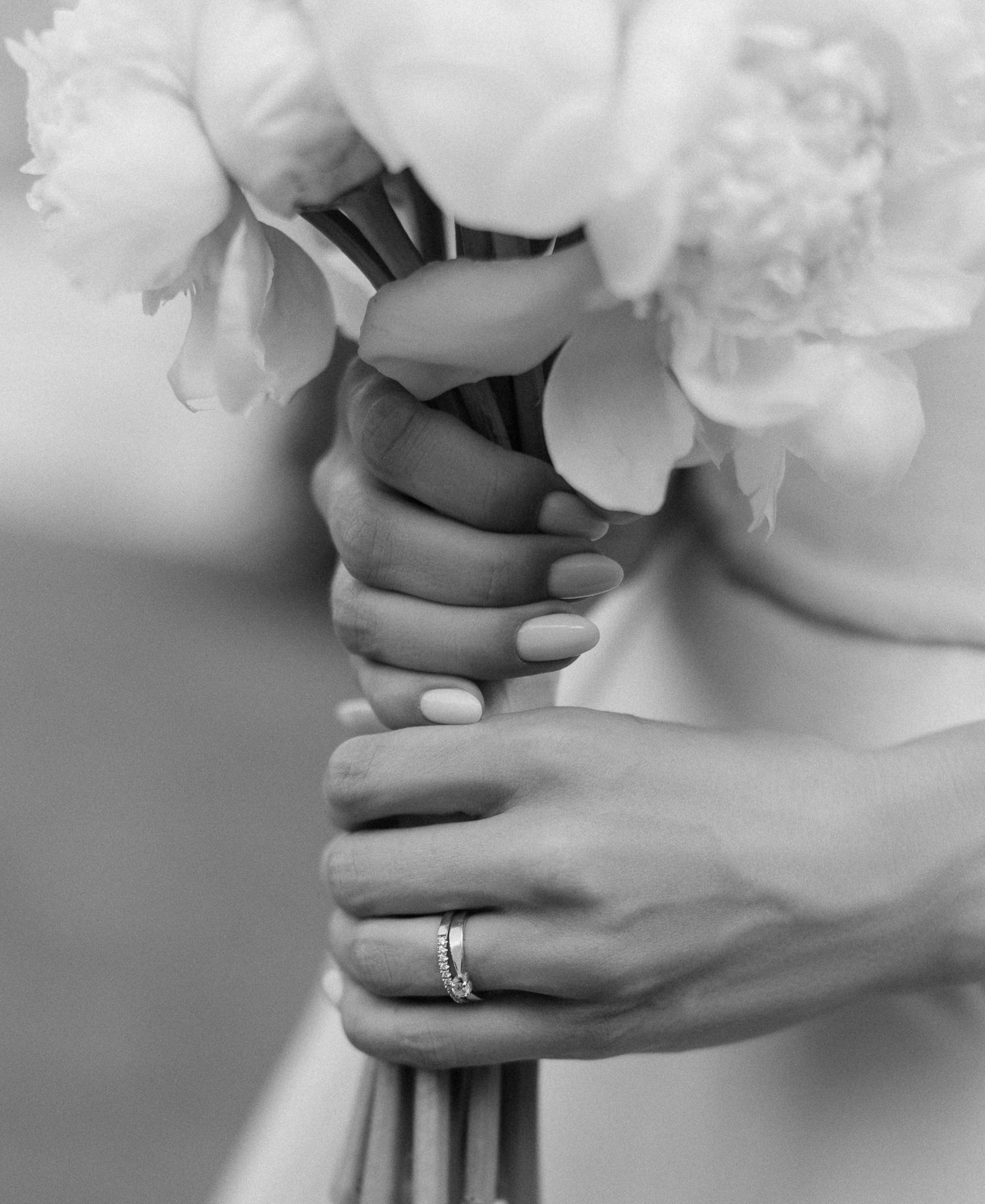 Baltų gėlių puokštė rankose